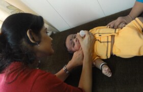 Young child below age 1 year is administered few drops of medicine by Dr Lipsa Shah