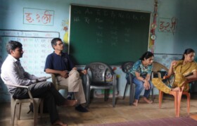 Team Suhrid discussing school progress with teacher