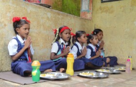 Kids praying before meal. Please note the habit of carrying water along during the meal. 